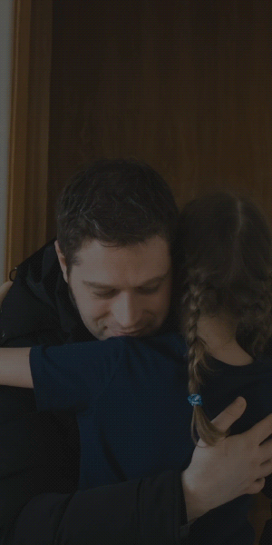 Hombre abrazando a una niña, imagen oscurecida usada como fondo.